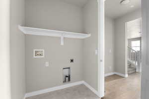 Washroom featuring hookup for a washing machine, light hardwood / wood-style flooring, and electric dryer hookup