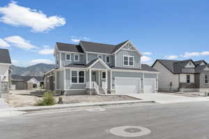 View of front of property featuring a garage, covered porch, and a mountain view