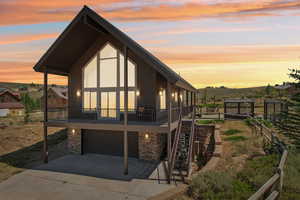 Property exterior at dusk with a garage and a deck