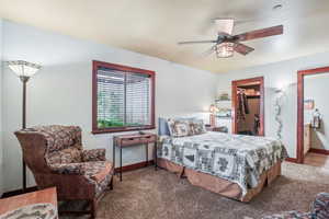 Carpeted bedroom with ceiling fan, a spacious closet, and a closet