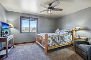 Carpeted bedroom featuring ceiling fan