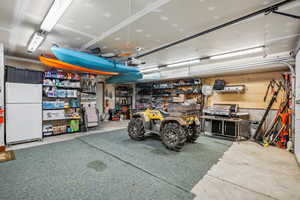 Garage with a workshop area and white fridge