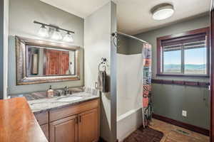 Bathroom with tile patterned floors, vanity, and shower / bath combo