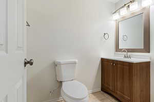 Bathroom with vanity, toilet, and tile patterned flooring