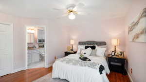 Bedroom featuring ensuite bath, light tile patterned floors, and ceiling fan