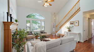 Living room with ceiling fan, skylights, and a high ceiling