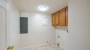 Laundry room with cabinets, electric dryer hookup, light tile patterned flooring, washer hookup, and electric panel