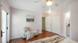 Bedroom with connected bathroom, ceiling fan, laminate floors, and a closet