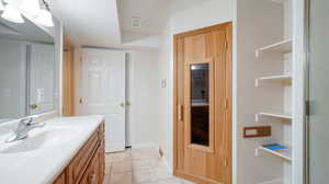 Bathroom with tile patterned floors, vanity, and sauna