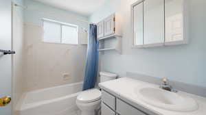 Full bathroom featuring shower / bathtub combination with curtain, vanity, tile patterned floors, and toilet