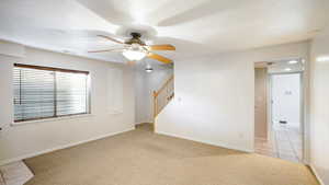 Family room with ceiling fan, a textured ceiling, and light tile patterned floors