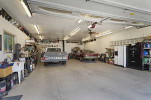 Garage featuring ceiling fan, a garage door opener, and a workshop area