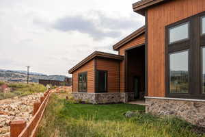 View of side of property featuring a mountain view and a yard