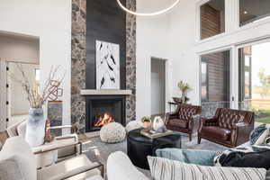 Living room with a high ceiling, a fireplace, and hardwood / wood-style floors