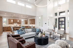 Living room with sink, light wood-type flooring, plenty of natural light, and a high ceiling