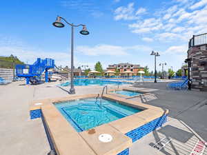 View of pool with a community hot tub and a patio area