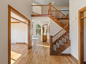 Foyer entrance featuring hardwood flooring, staircase  and a towering ceiling