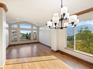 Dining and Living Room area featuring, picture windows,  chandelier, lofted ceiling, and hardwood loors