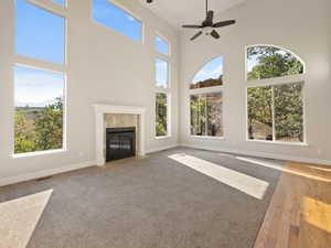 Great room with a towering ceiling, plenty of natural light, fireplace