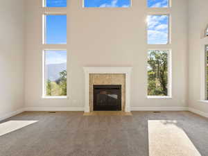 Great  room featuring a towering ceiling, plenty of natural light, and carpet