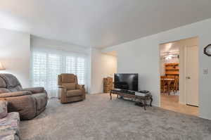 Living room with light colored carpet and ceiling fan