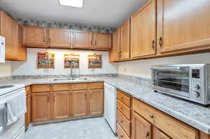 Kitchen featuring sink, light tile patterned floors, and appliances