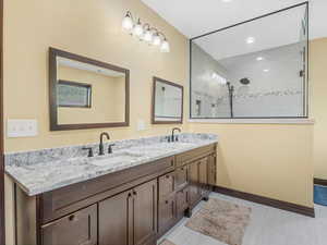 Full bath with double vanity, walk in shower, and recessed lighting