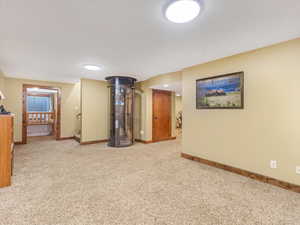 Empty room with light colored carpet and baseboards