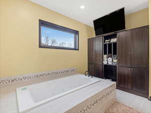 Full bath with a jetted tub and recessed lighting