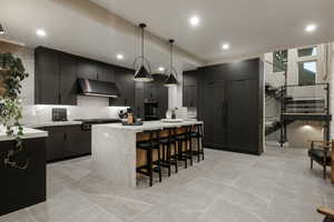 Kitchen with tasteful backsplash, a kitchen breakfast bar, pendant lighting, stainless steel appliances, and a kitchen island