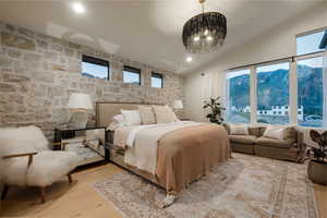 Master Bedroom featuring lofted ceiling, a mountain view, light hardwood / wood-style flooring, and designer chandelier