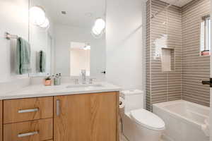 Full bathroom with vanity, toilet, and tiled shower / bath