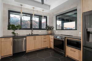 Kitchen with pendant lighting, a mountain view, stainless steel appliances, sink, and decorative backsplash