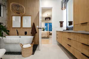 Bathroom featuring vanity, tile patterned flooring, and a tub to relax in