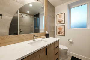 Bathroom with toilet, tile patterned floors, and custom vanity mirror