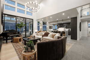 Living room featuring a chandelier, light hardwood / wood-style floors, and a high ceiling