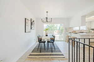 Tiled dining area with a notable chandelier and sink