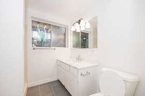 Bathroom with vanity, toilet, and tile patterned flooring