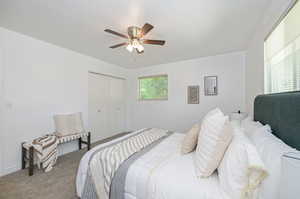 Carpeted bedroom featuring a closet and ceiling fan