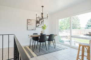 Tiled dining space featuring a notable chandelier