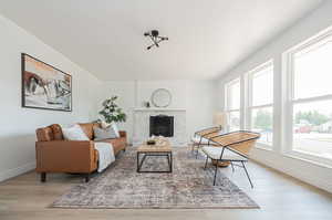 Living room featuring a tiled fireplace and light wood-type flooring