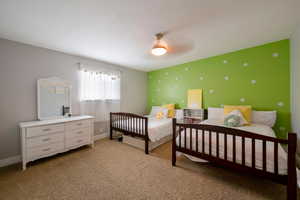 Carpeted bedroom with a textured ceiling and ceiling fan