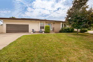 Single story home with a garage and a front yard