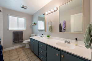 Bathroom featuring vanity, toilet, and tile patterned floors