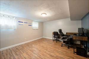 Office featuring light hardwood / wood-style floors and a textured ceiling