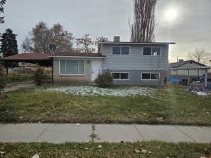 View of front of home with a front lawn and a carport