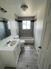 Full bathroom featuring vanity, tiled shower / bath, tile patterned flooring, and toilet