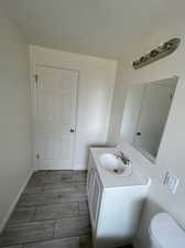 Bathroom with vanity, toilet, and tile patterned flooring