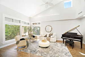 Sitting room with ceiling fan, high vaulted ceiling, hardwood / wood-style flooring, and a healthy amount of sunlight