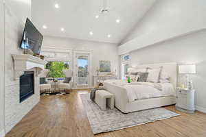 Bedroom with ceiling fan, high vaulted ceiling, light hardwood / wood-style flooring, and access to exterior